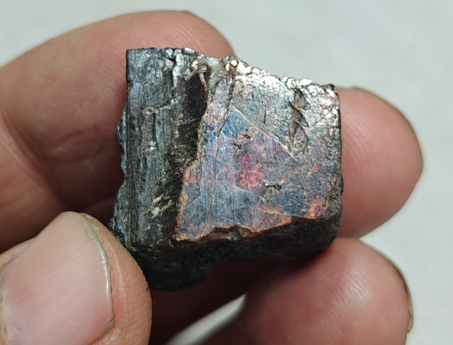 Natural rare mangano tantalite specimen with metallic and iridescent surface colours